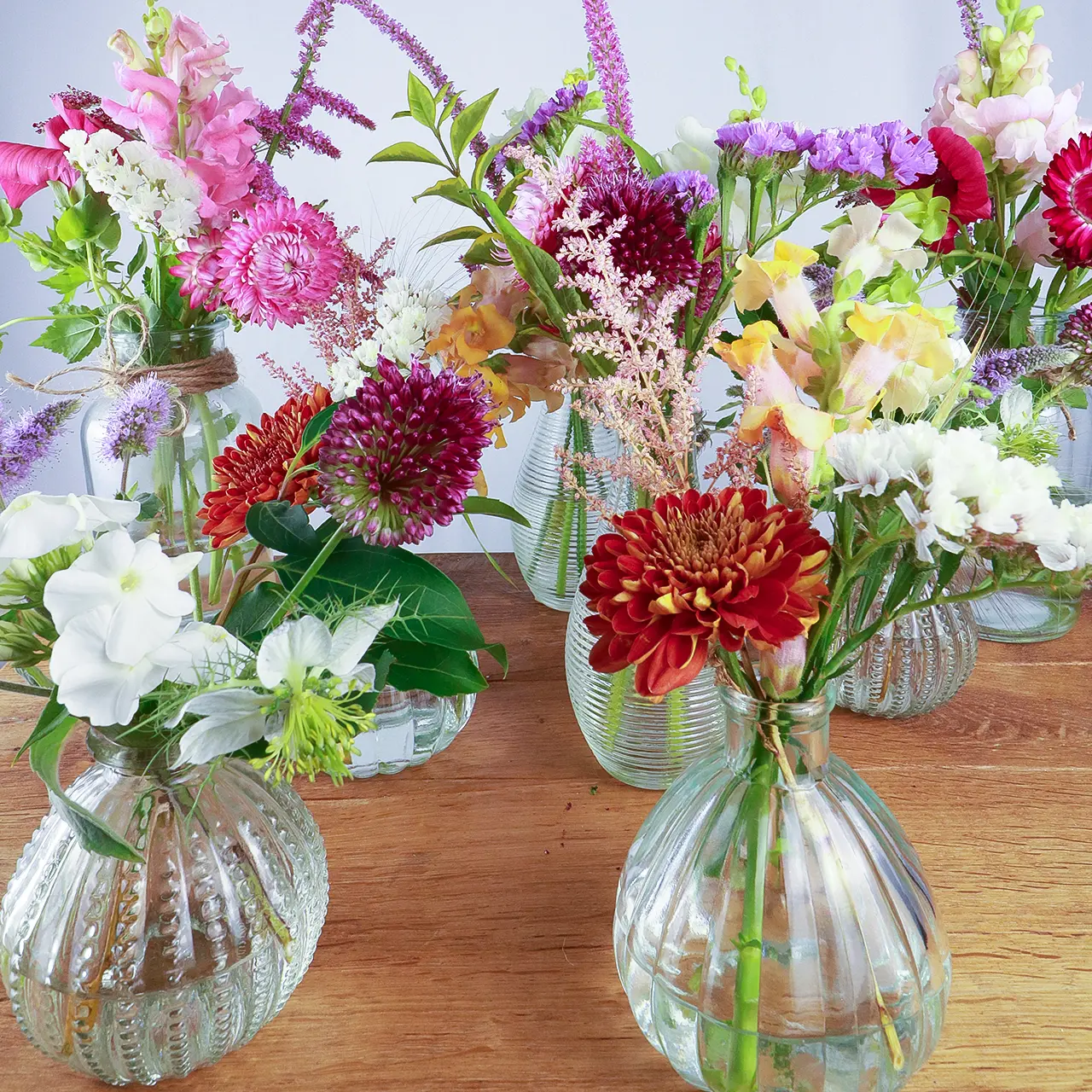 Collection of Marguerite Rose bud vase arrangements featuring vibrant sustainably-grown Devon flowers for businesses and events