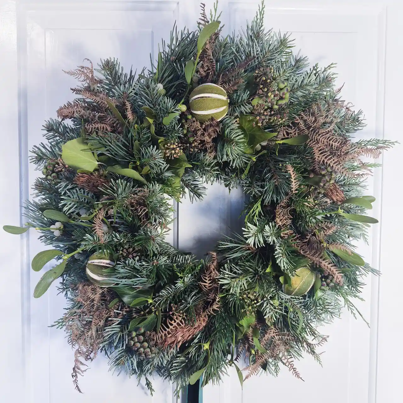 The Winter Romance large moss Christmas wreath with mistletoe, pine, dried citrus, ferns and seed heads handmade in Devon