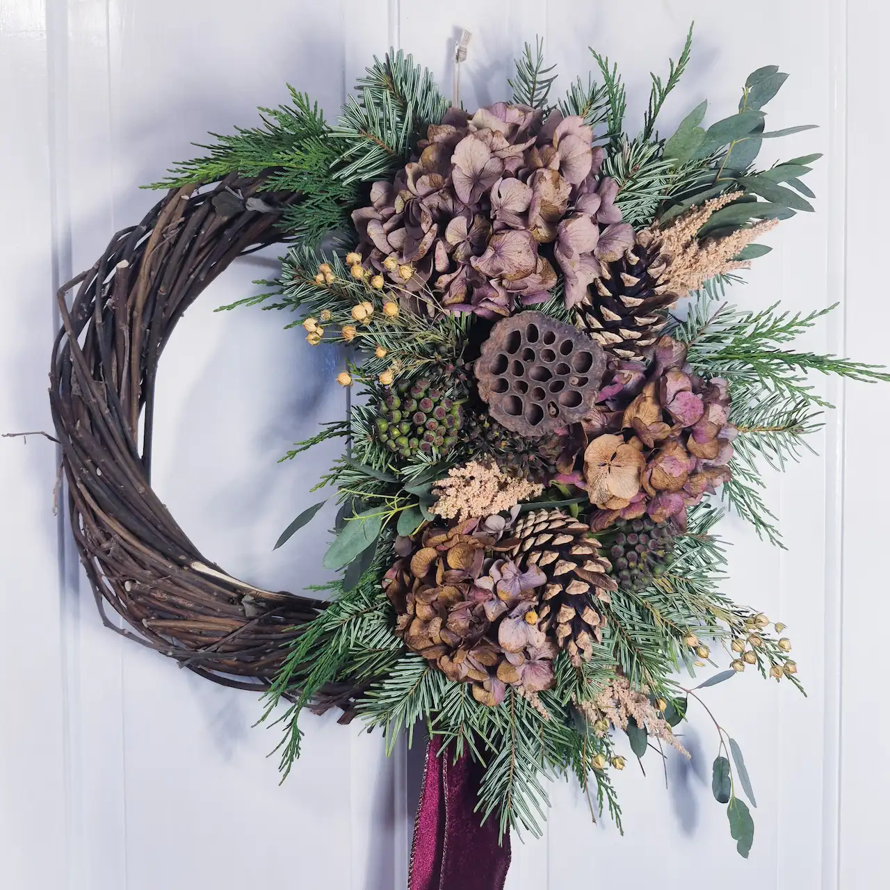 The Dartmoor Heather large willow Christmas wreath with dried hydrangea, lotus pods, fir cones, pine and bay handmade in Devon with handwoven willow base