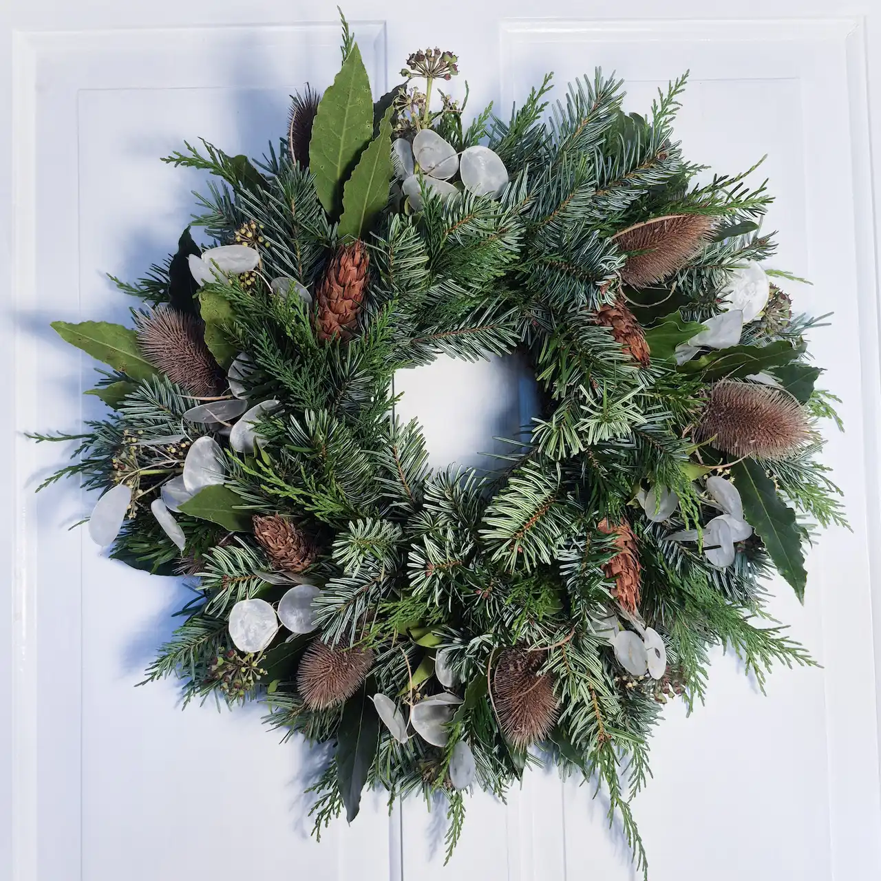 The Silver & Spice medium moss Christmas wreath with silvery honesty seed pods, pine cones, teasels, bay, ivy and pine handmade in Devon